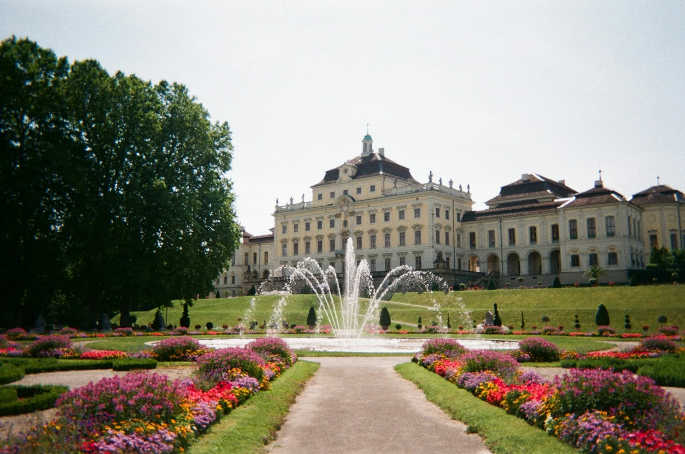 Residenzschloss Ludwigsburg hinter einem Springbrunnen und bunten Blumenbeeten im Park des Blühenden Barocks